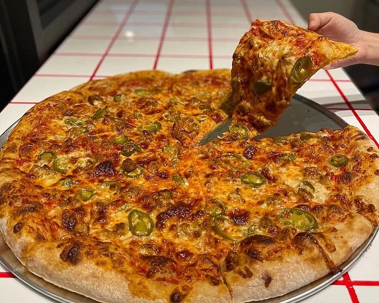在社群討論度爆表的「The Slice Shop」是全台首間專注於酸種發酵披薩（sourdough） 的專賣店，採用傳統酸種老麵長時間發酵，餅皮外層金黃酥脆、內部輕盈柔軟，咬下帶微微酸香與彈性。