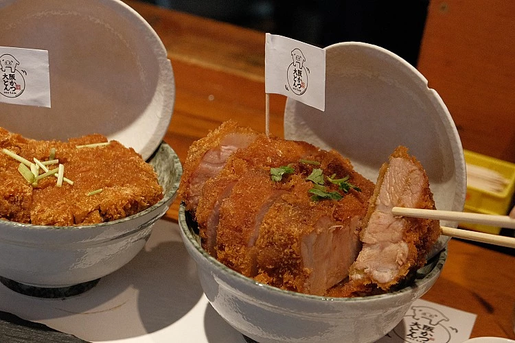 當蛋液與海苔覆蓋在那沉甸甸的豬排上,底下的白飯吸飽了肉汁,口感濕潤卻不軟爛。