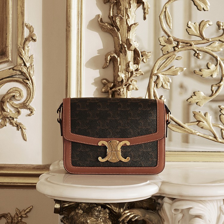 Celine老花「Triomphe」有著獨特的浪漫與故事性。它誕生於1970年代，靈感來自品牌創辦人 Céline Vipiana 女士在巴黎凱旋門前車輛拋錨的偶然一瞬，她被廣場周圍鎖鏈上的「雙C」圖樣深深吸引，進而設計出早期名為 Macadam 的印花。