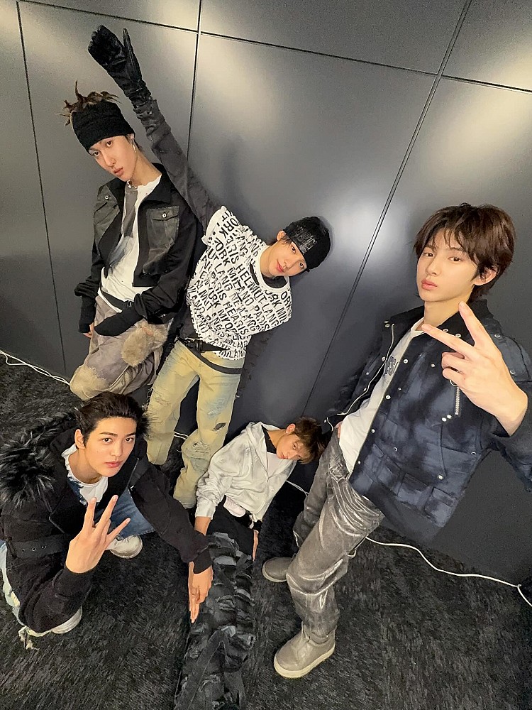 在這組後台合照中，Cortis 全員以黑、灰為主調的造型亮相，展現濃厚的暗黑機能、Y2K穿搭的風格。短版外套、刷舊丹寧、工裝褲與拼接長褲交錯運用，搭配頭帶、毛帽、手套與護臂等配件點綴，內搭白T或圖騰上衣作為對比，堆疊出豐富視覺層次，讓整體造型在單一色系中依然充滿細節