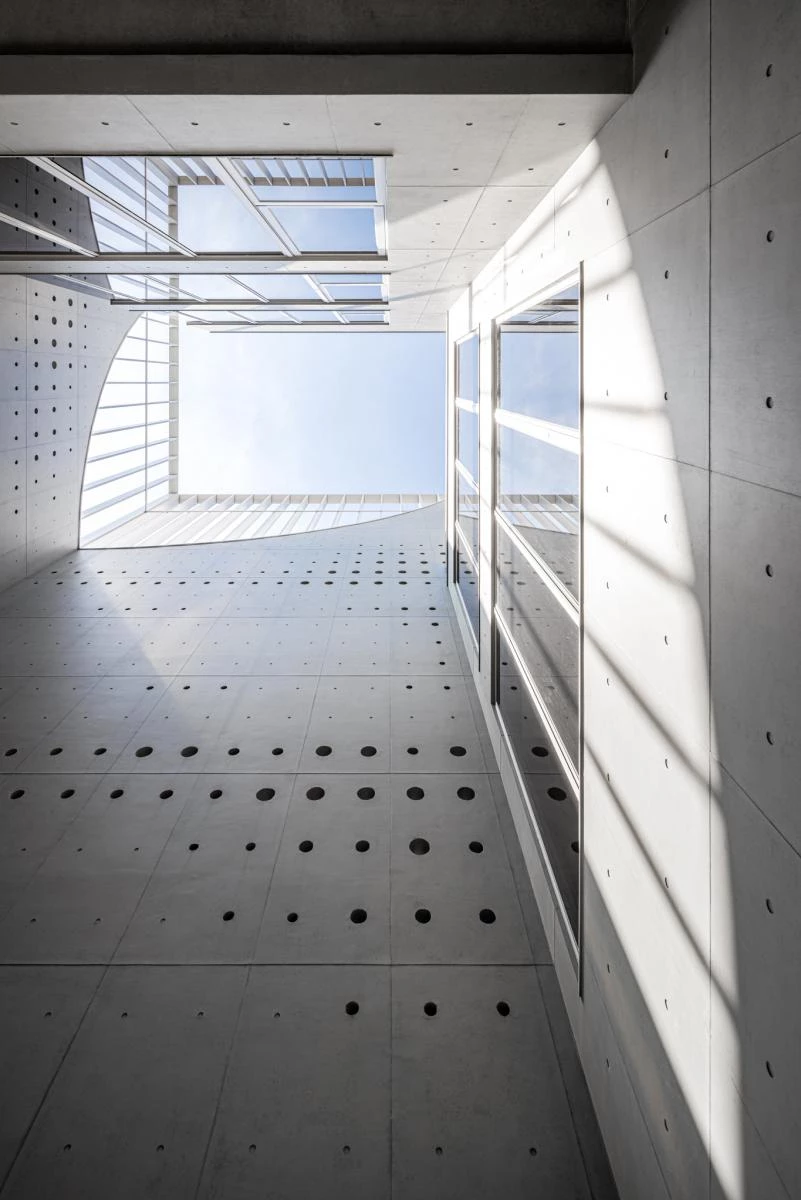 由建築事務所 Air Matters 與 16 ARCH STUDIO 攜手設計，台南街道上緩緩迎來一座極簡混凝土建築：日光軌跡。不同於過去我們對太陽能公司的既定印象，其外觀是一座沉穩的混凝土立方體，靜靜坐落於繁忙街道上。在這座五層樓的建築量體中，設計團隊嘗試打破傳統辦公空間的類型限制，以「光線」作為設計語彙，打造一座象徵創新與永續的城市新地標。