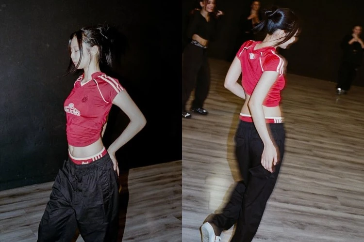 Jennie身穿紅色修身運動上衣，搭配黑色寬版長褲與外露的運動內褲，展現強烈動感與鮮明風格主張。