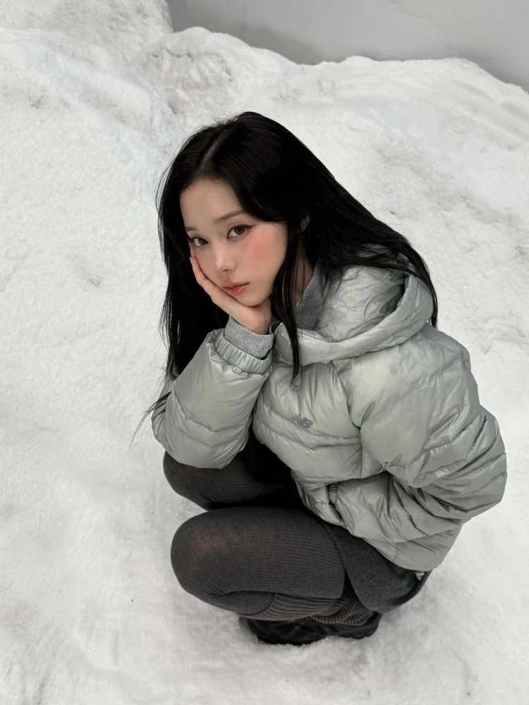 金冬天真的很會用穿搭打造女孩感！冬日的雪地裡，她同樣用短版羽絨外套來穿搭，這一套則是運用同色系的格雷灰，從New Balance的銀灰色羽絨服，金屬光澤感自帶時髦濾鏡，下半身搭配灰色短裙、高磅數絲襪、中長版襪套，不只有保暖的功能性，更有穿搭的層次感！
