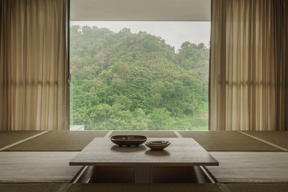 餐廚區的中島與餐桌設計,讓家人圍聚在共享的料理空間,天花板高度與材質錯落,區隔不同空間功能而不設實體隔間,地坪與扶手線條垂直延伸,連貫視覺語境,營造整體性的空間印象。