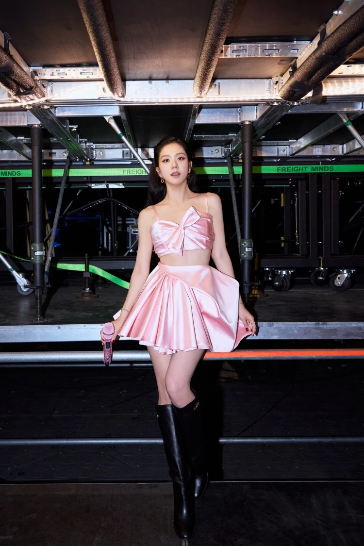 Jisoo 身著一件粉色套裝,這件服裝是由 Jonathan Anderson 親自為她所訂製,整體服裝以搭配蝴蝶結的短板上身,以及不規則百摺短裙所設計>