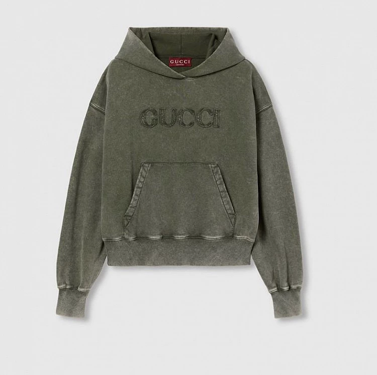 Gucci帽T以仿舊染色呈現柔霧般的灰綠色澤,視覺低調卻很有深度。正面同色刺繡標誌刻意不張揚,反而讓質感更耐看。