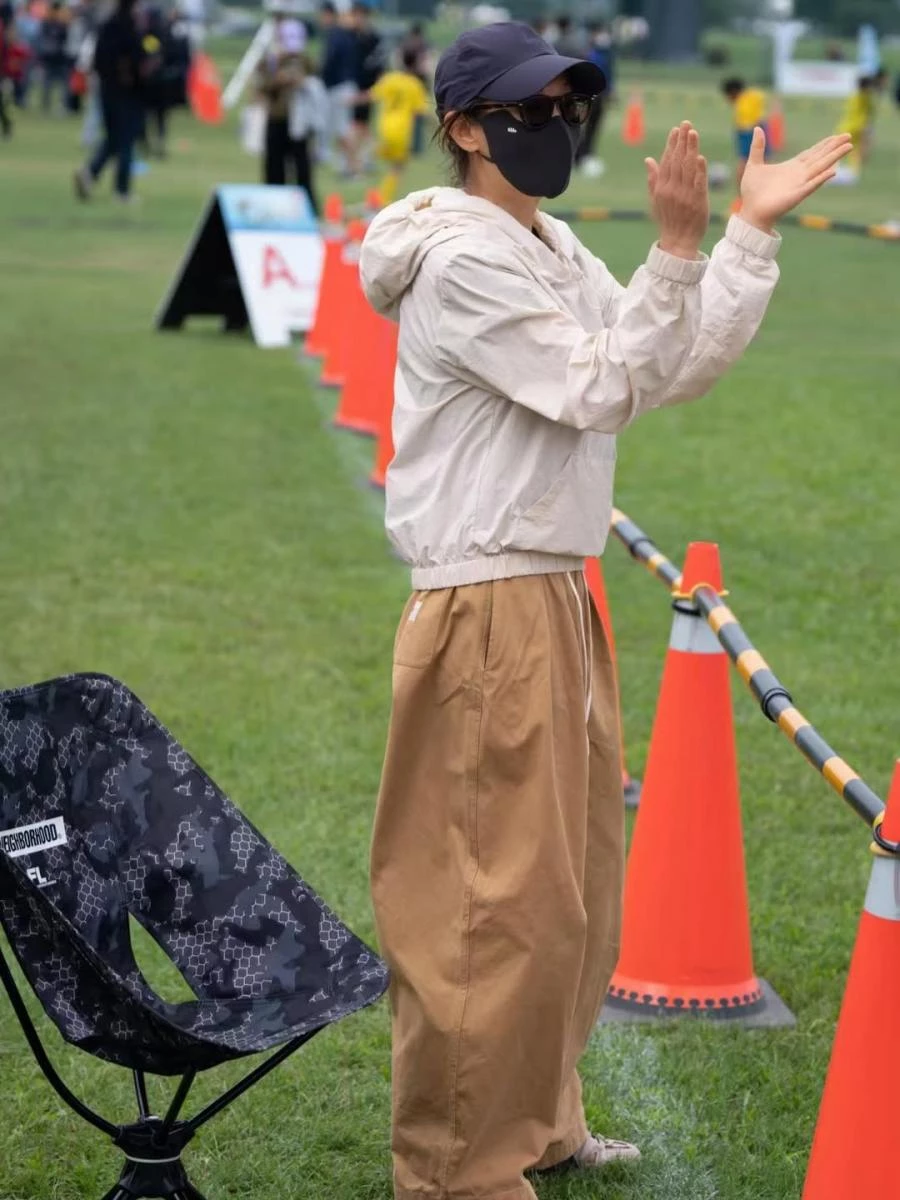 機能風真的是劉若英最常見的穿搭,這套米色輕量外套搭配卡其色寬褲,整體色調柔和而一致,營造出自然不費力的生活感。外套剪裁偏短、線條俐落,讓身形比例不被壓低,也增添幾分俐落感;下身寬褲則保留足夠空間,行動時自在流暢,與戶外運動場景完美契合。棒球帽與墨鏡的加入,替整體造型更顯帥氣,不只實用,也讓穿搭更有層次。這樣的搭配沒有刻意追求年輕,而是透過舒適版型與溫和配色,呈現出輕鬆、耐看又很有精神的減齡狀態。