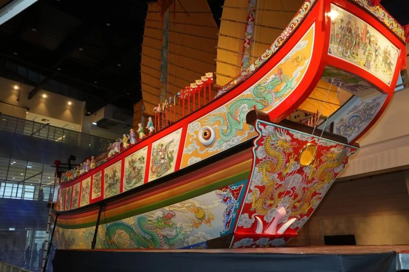 作為屏東最具代表性的民俗之一,「東港迎王平安祭典」已登錄為國家重要民俗,並列為無形文化資產,其知識體系與傳統工藝的傳承,成為地方文化保存的重要指標。屏東王船文化館除作為展示空間外,也是一處關於地方認同、文化治理與產業共生的想像平台。館舍由趙建銘建築師事務所操刀設計,規劃為五層樓建築,透過沉浸式體驗,引導觀者認識王船文化的歷史與技藝。