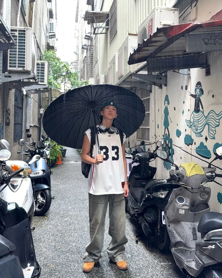 Seventeen Hoshi這套台北街拍造型，以上寬下寬的穿搭邏輯，展現運動混搭機能的時髦感，上身愛迪達的白色無袖籃球背心，以及灰色洗舊感的Entire Studios寬版牛仔褲，其中最吸睛的配件莫過於這款Tumi多口袋後背包，來自經典Alpha系列