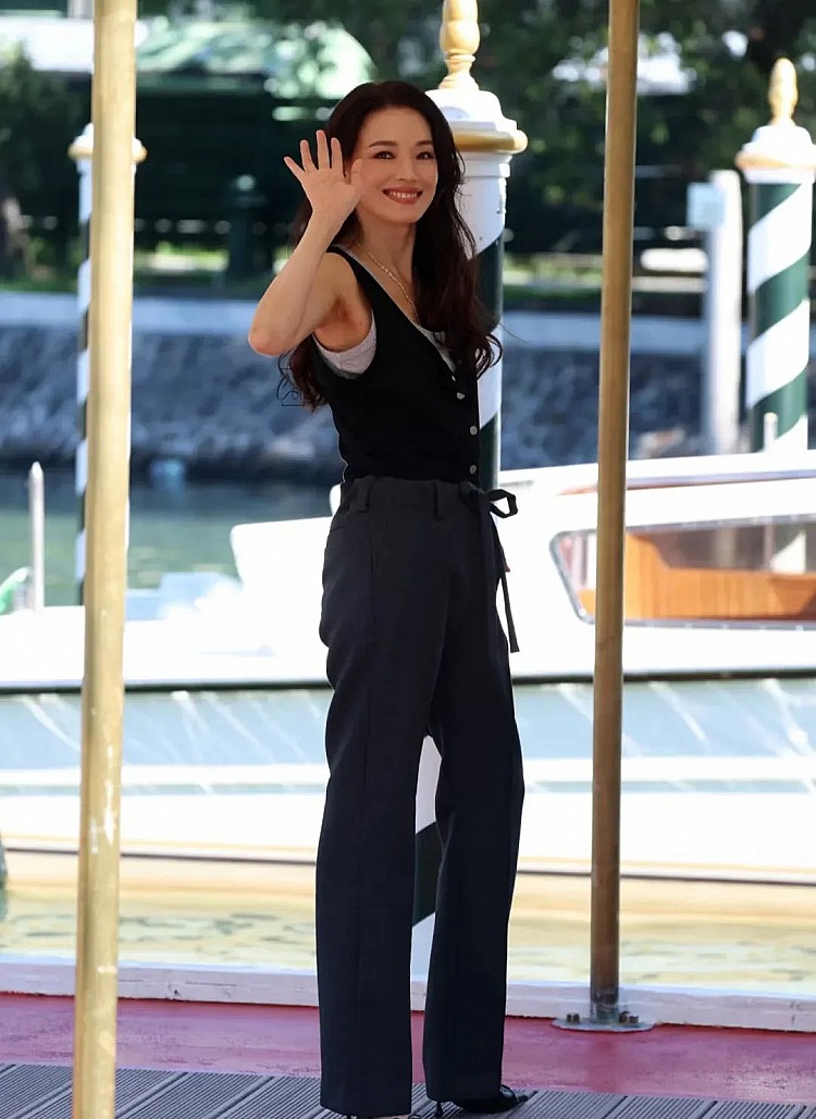 舒淇的背心穿搭一件不夠，兩件來湊！在威尼斯影展時，以設計師品牌Mark Gong的黑色背心、灰色背心兩件疊穿來增加穿搭的層次感，同時更顯得減齡，下身搭配灰色西裝抽繩長褲，寬鬆卻修長的版型讓腿部線條更顯筆直，與俐落背心形成平衡，鞋履選擇尖頭高跟鞋，低調卻拉長比例，整體造型自在不失高級感。