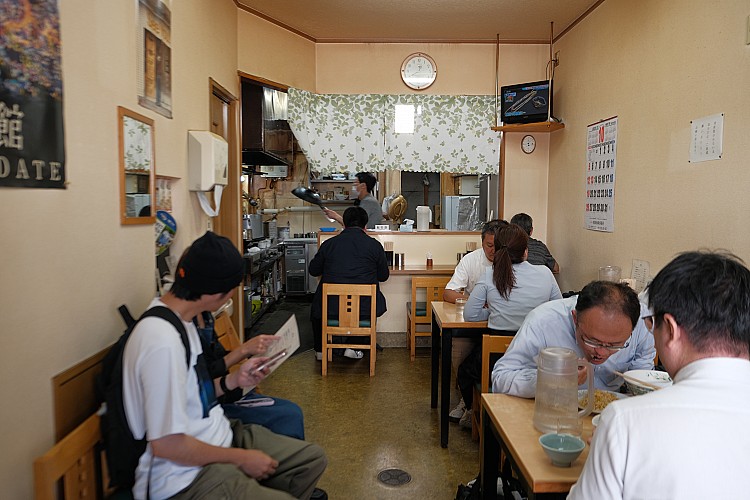 店內僅15席，小巧卻充滿老味道。若想嚐到那碗傳說中的鹽味拉麵，務必提早前往排隊，店門雖在11點半開啟，但聰明的老饕早在11點便已等候。