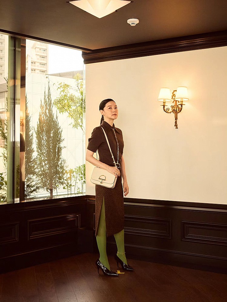 李英愛這套造型選擇Gucci深咖啡色套裝，沉穩優雅卻不失時尚張力，下身搭配亮眼的草綠絲襪打破沉悶，瞬間注入年輕活力。腳踩黑色尖頭高跟鞋，在配色上形成撞色對比，這套穿搭的減齡關鍵就在於：以沉穩底色為主，再透過鮮明配件或內搭增加活潑元素，有畫龍點睛的效果！