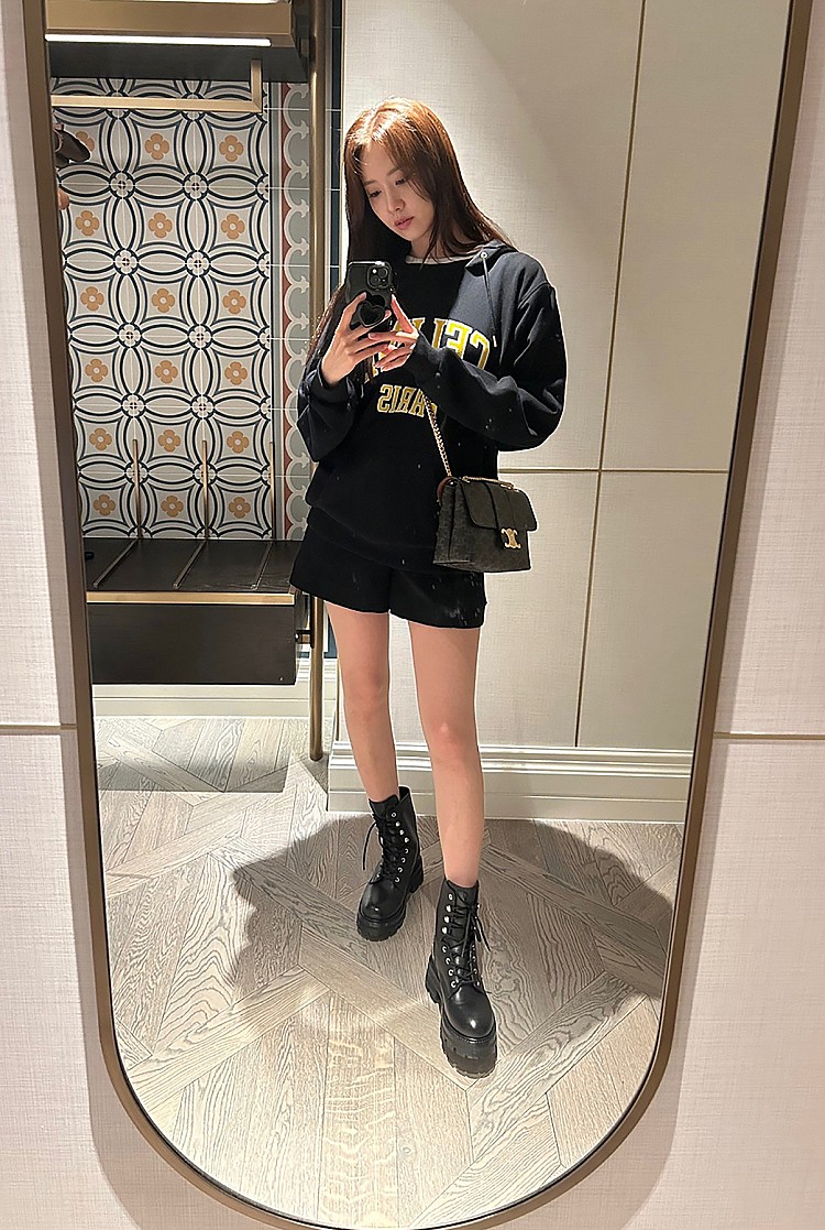 「大學T＋短褲」組合是完勝機場時尚的必勝組合，不只具有舒適度，更有種隨性的時髦感，她選擇寬鬆版型的Celine字樣黑色大學T，下身搭配簡約短褲，讓腿部線條完美展現。鞋履則以厚底長靴收尾，不僅增加酷帥氛圍，還能修飾比例，完全看不出出道18年！