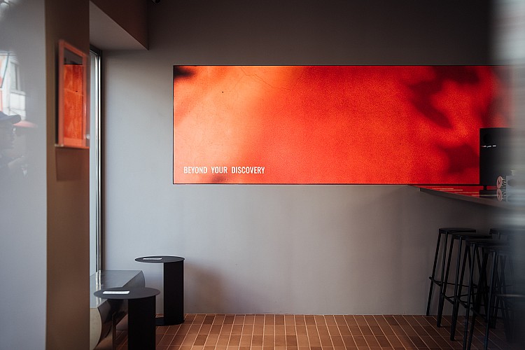 從顧客視角望向內場，鏡面與玻璃的穿透感讓咖啡製程一覽無遺