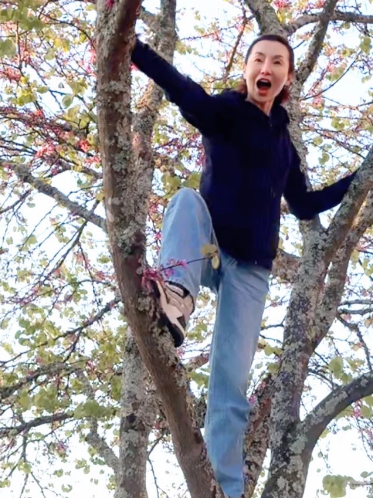 用牛仔褲搭配連帽外套，簡簡單單的穿搭中卻很有青春氣息，張曼玉選擇了一件黑色連帽外套，搭配淺藍色牛仔寬褲，有著水洗感的色調，腳上踩著白、黑與米色拼色球鞋，整體氛圍簡單俐落卻不失活力。