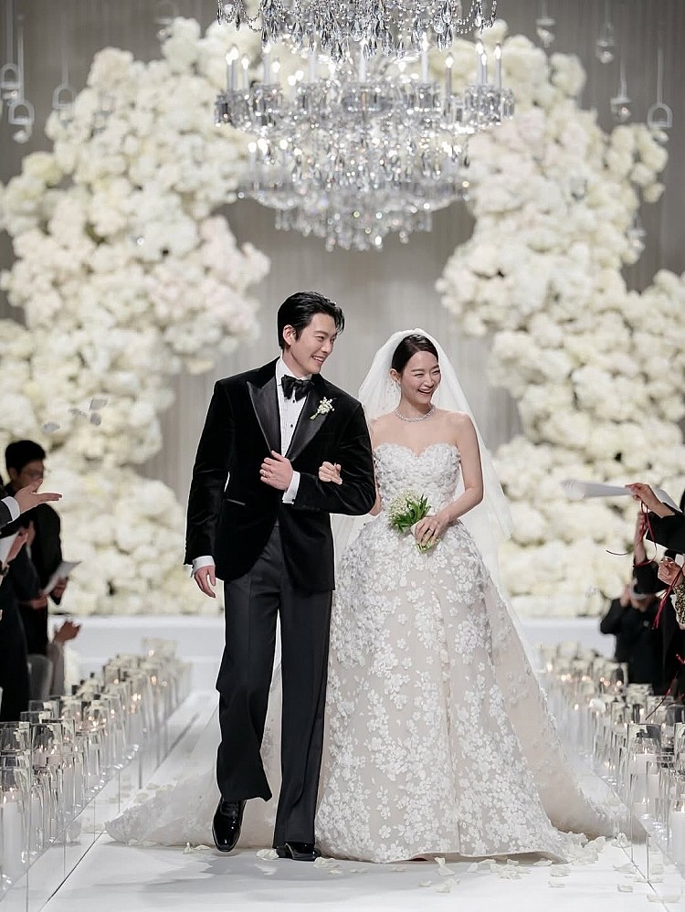 申敏兒主婚紗來自 Elie Saab 2026春夏新娘系列，定價約2萬8600美元，換算約 4200萬韓元、近新台幣98萬元。整件禮服以心型的剪裁展露出鎖骨線條，立體的花卉刺繡點綴，並適當的留白結合蕾絲細節，將頭髮簡單乾淨盤起，僅以Louis Vuitton白金鑲鑽Galaxie項鍊點綴，彷彿是仙女走入凡間。