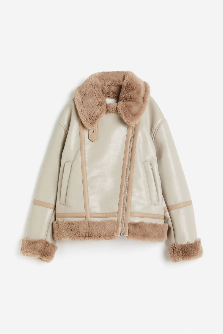 這款機車夾克以塗層面料打造挺度，搭配絨面領與金屬扣，呈現硬派中帶溫度的質感對比。