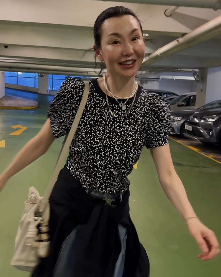 張曼玉這套穿搭的核心依然落在牛仔褲，上身搭配黑底白點的印花上衣，微泡泡袖細節增添了立體層次與女性魅力。她選擇的牛仔褲版型經典俐落，比例簡單耐看，透過 Celine Triomphe皮帶勾勒出清晰腰線，巧妙拉長下半身線條。腰間隨性繫著一件外套，更顯自在卻不失態度；手中拎著 Loewe Flamenco抽繩包，在隨性丹寧與高級質感之間找到平衡，完美演繹出休閒與時髦並存的氛圍。