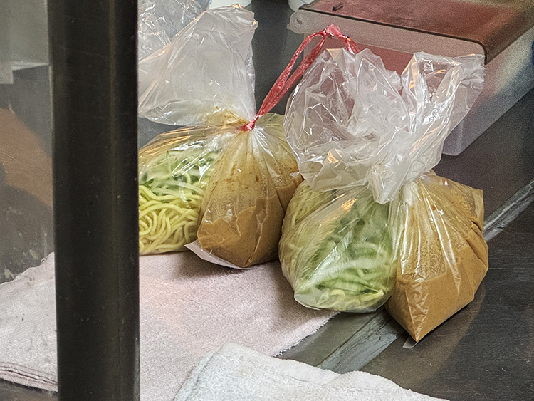 環南市場的夜從不真正安靜，炭香、油香、蛋香在巷弄間流動，像另一場醒著的市集。