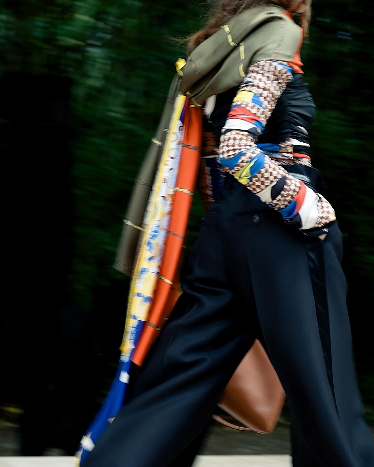 若Phoebe Philo的絲巾代表理性、Slimane的頸巾象徵搖滾，那Rider的版本則在兩者之間找到平衡點切入，。輕盈絲巾延伸至外套領口、肩線與腰間，隨風飄動形成流線感，呼應他對「輕盈與自由」的詮釋。這些細節不僅是造型亮點，也成為本季的重要象徵語言——柔軟，但不脆弱。