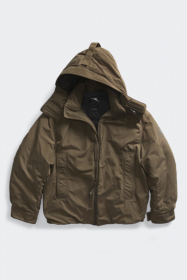 短版剪裁搭配抽繩下擺設計，線條可依穿著狀態自由調整，既保有份量感，又不會讓身形顯得厚重。隱藏式拉鍊口袋刻意弱化機能視覺，讓整體外型回歸純粹，低調卻很有質感。