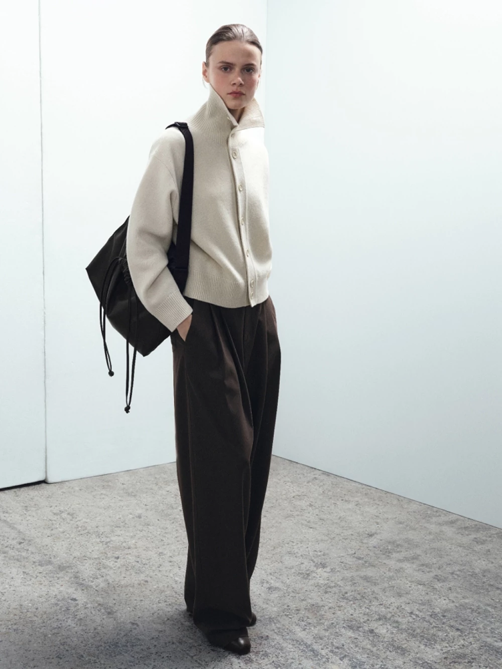 Uniqlo U柔軟抽繩肩背包採用柔軟仿皮革材質,正面以抽繩束口打造自然抓皺的立體感,慵懶又有設計感。