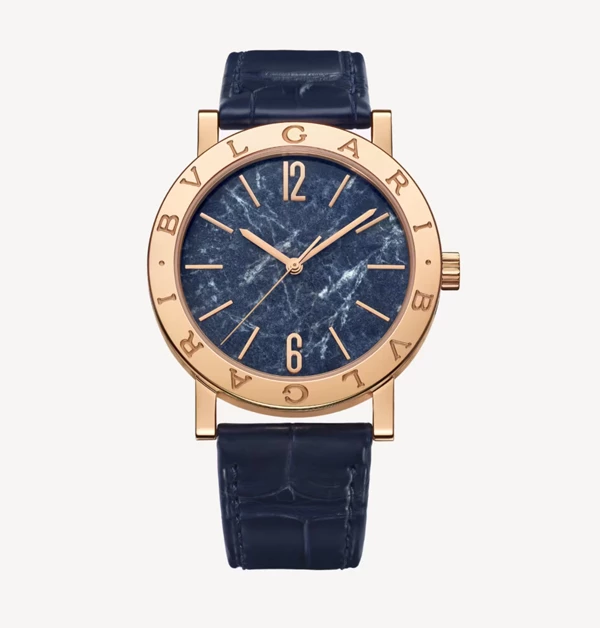將古羅馬美學推向藝術品等級代表作的「Bvlgari Bvlgari」腕錶系列。此錶款推薦,以溫潤的玫瑰金錶殼內鑲嵌上了獨一無二的天然藍色大理石面盤,讓每只腕錶都呈現獨特的石紋肌理。搭配經典的雙Logo刻印錶圈與深藍色鱷魚皮錶帶,在低調中流露出極具張力的奢華品味。它不僅完美呼應了張國榮生前鍾愛的Bvlgari經典設計,更為追求獨特品味的佩戴者,在正裝與重要場合中點綴出不凡的藝術氣息。(商品價格約:NTD 554,000)