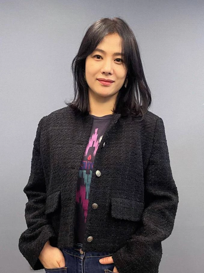 黑色短版小香風粗呢外套搭配深色牛仔褲,內裡露出一截帶有迷幻紫粉色調的印花上衣,完美平衡了粗呢外套容易顯得老氣或過於貴氣的框架。黑白金釦的外套質感滿分,短版剪裁更在無形中拉高了身形比例。