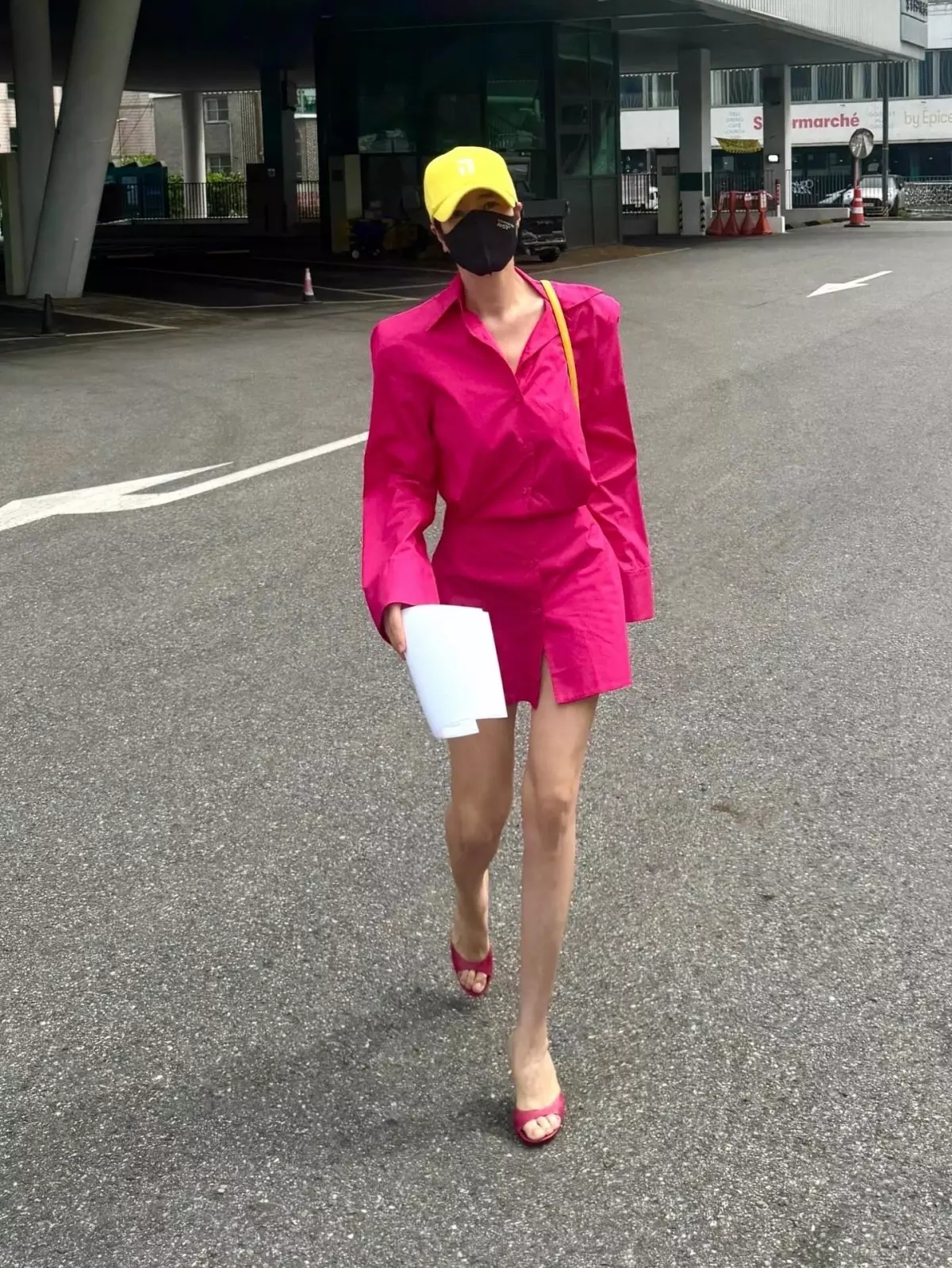 金憓秀以桃紅色長版襯衫式洋裝現身街頭，戴上亮黃棒球帽跳色，腳踩同為桃紅色的細跟穆勒涼鞋，同色系從裙擺延伸到腳尖，腿看起來更長。