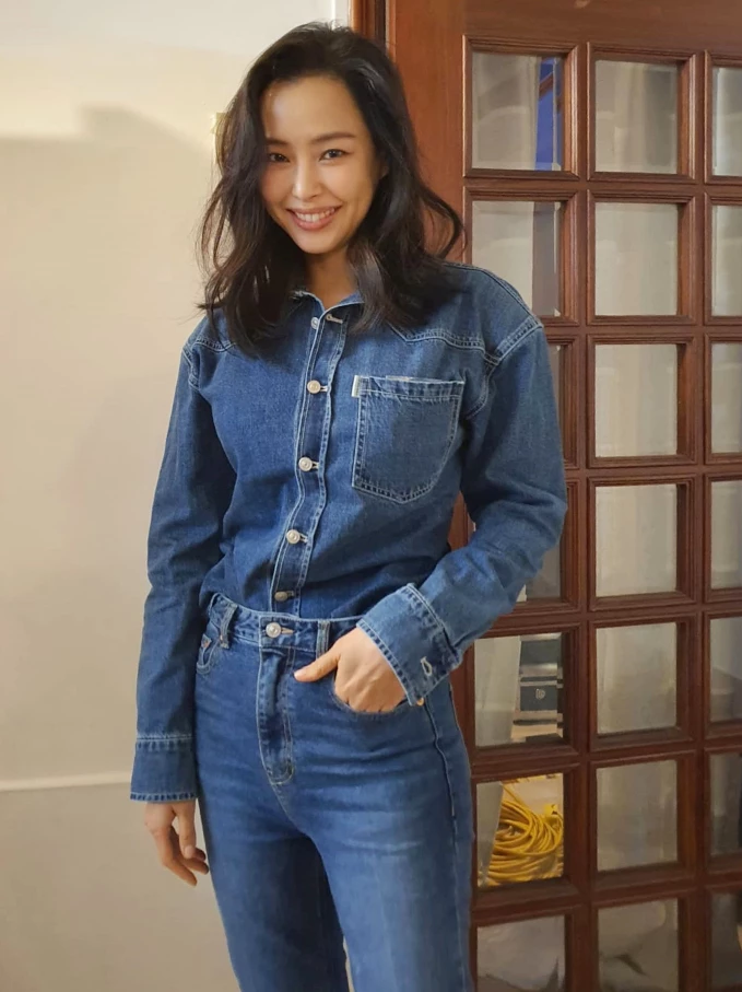 Denim on Denim，一直都是時尚界不敗的減齡神技！李荷妮的這套，直接將修長比例拉到極致。不用過多的飾品堆疊，光靠牛仔布料本身的硬挺質感與大方笑顏，就展現出強烈的個人氣場。牛仔單品是無痛減齡的首選！但全套丹寧穿搭時，記得將襯衫紮入褲頭，或者稍微拉高腰線，利用質感硬挺的面料來修飾身形線條，立顯俐落精神。