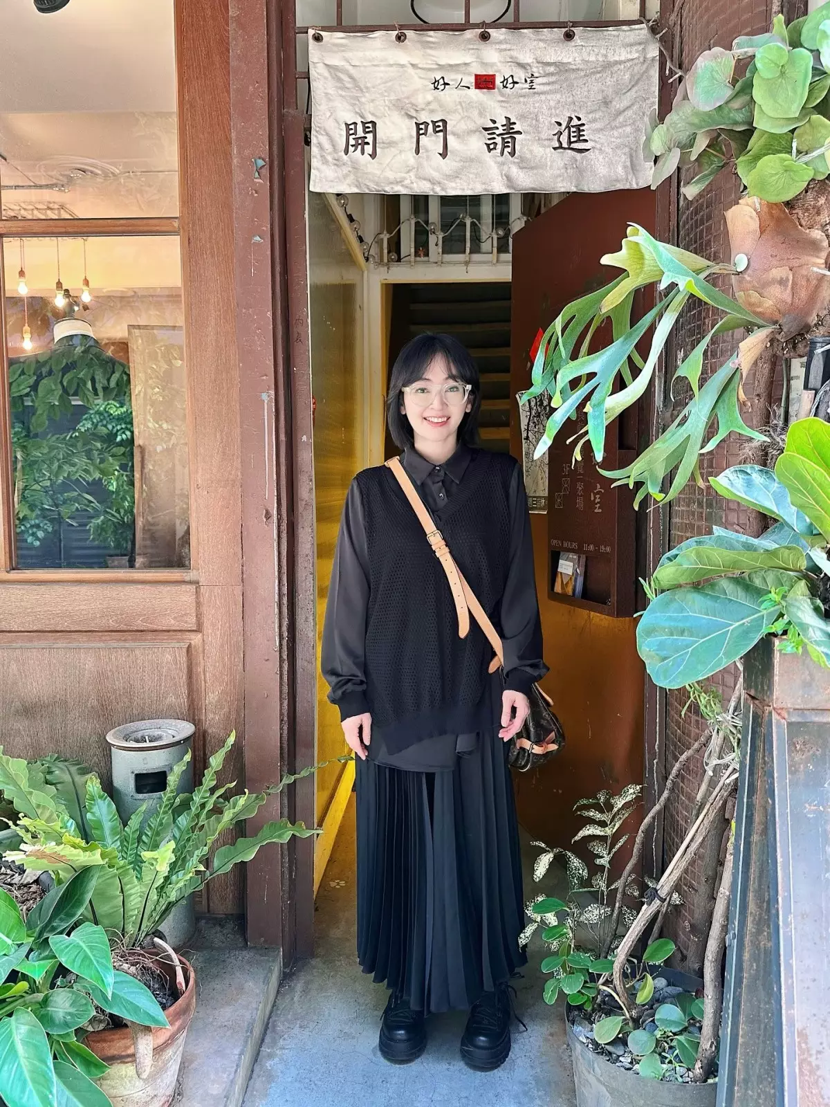 蔡燦得以黑色鏤空針織背心疊穿黑色長袖襯衫,下身搭配黑色百褶長裙與厚底鞋,斜背LV老花包,全黑層次俐落又減齡。