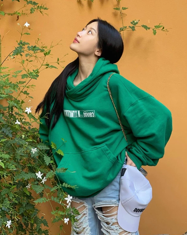 我好愛這種高彩度的運動風穿搭，綠色不僅把皮膚襯得超級白皙，連帽上衣隨性的慵懶感更散發出滿滿的活力，彷彿隨時準備好展開一場愉快的午後城市漫遊。週末出遊，想穿得舒服又不想顯得沒精神，不妨挑選一件亮色系（如草綠、寶藍或柔粉）的寬鬆帽T。下半身，則可搭配簡單的牛仔褲或短褲，就能輕鬆營造出充滿朝氣的時髦休閒感。