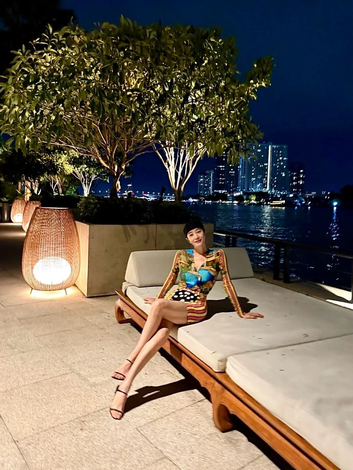 金憓秀以絲巾印花的長袖緊身短洋裝，搭配黑色細帶高跟涼鞋，在河畔夜景前展現逆天長腿，繽紛印花吸睛減齡，短裙加細帶涼鞋把腿比例拉到最長。