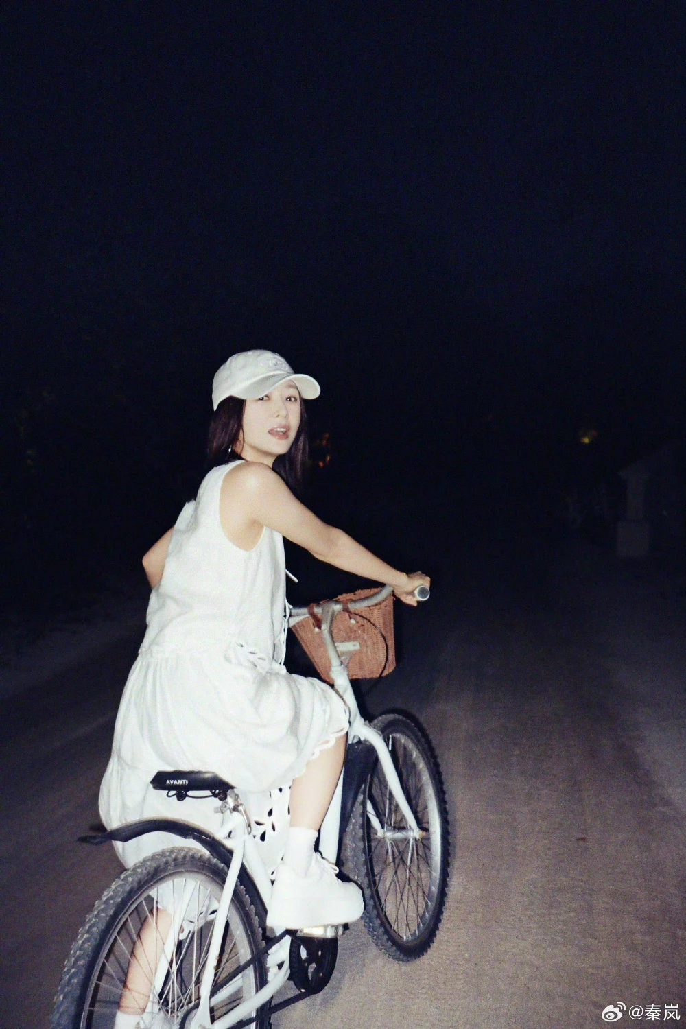 秦嵐夜騎腳踏車,以白色抓皺長洋裝搭配白色棒球帽、白色短襪與白色球鞋,全白造型清爽又減齡。
