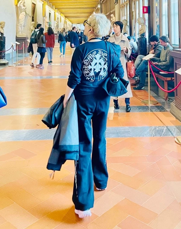 這張在歐洲藝術長廊裡拍下的背影照,藍心湄身穿Chrome Hearts經典十字架圖騰黑色長袖上衣與運動長褲,手拿外套,展現出渾然天成的霸氣與率性。選擇剪裁質感好、帶有簡約潮流品牌標誌的黑色連帽衫或運動套裝,搭配俐落的短髮或包頭,不僅穿著體感極佳,視覺上更能展現出不隨年齡妥協的年輕酷勁。