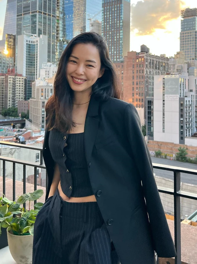 李荷妮將細條紋西裝外套披在肩上，裡面內搭同系列條紋短版背心與高腰寬褲，微微露出纖細腰線。西裝的硬挺與短版內搭的微辣完美結合，完美體現了當代女性的自信與時髦。