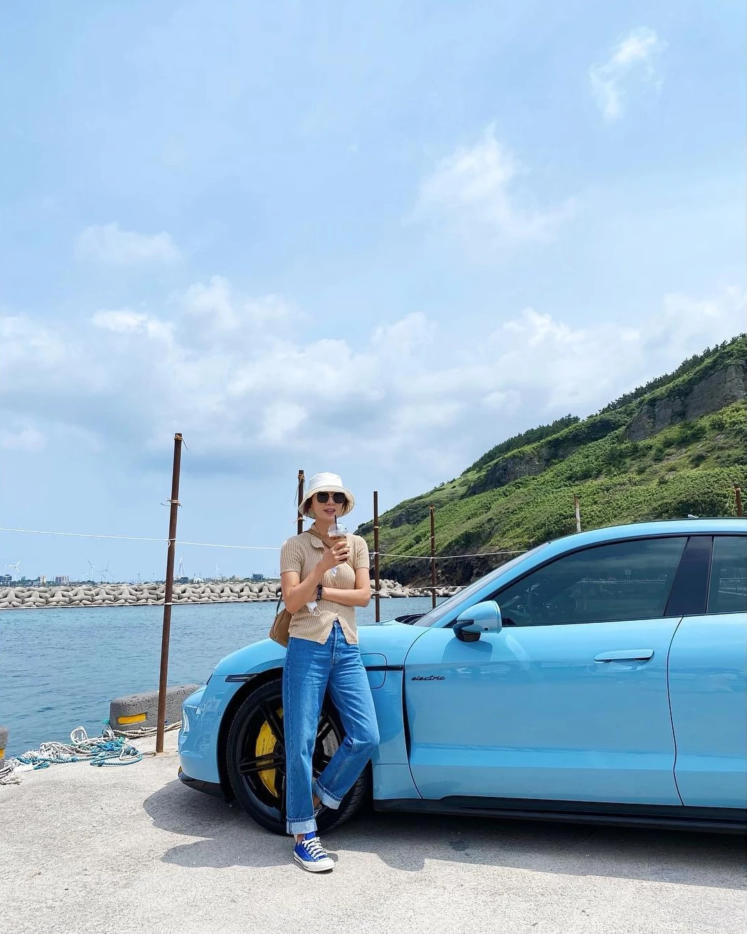 金喜愛在海邊以米色針織Polo短袖搭配藍色捲邊直筒牛仔褲,腳踩藍色Converse帆布鞋、戴白色漁夫帽,清爽度假又減齡。