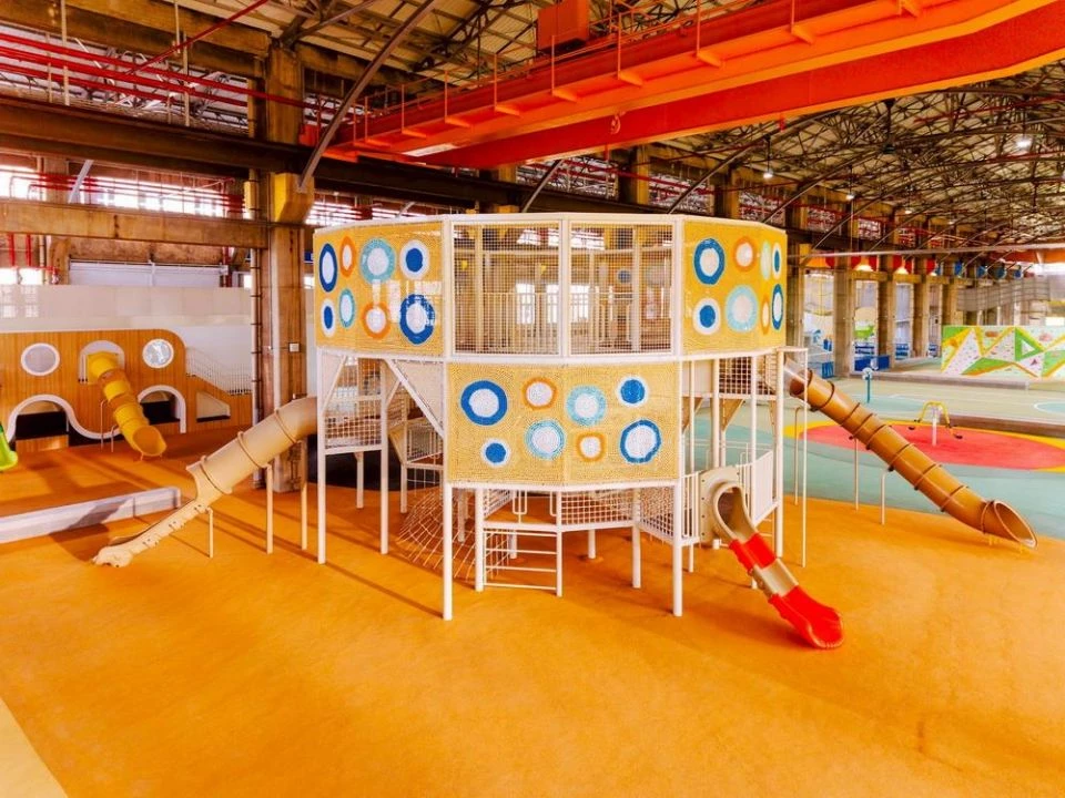 高雄親子遊樂園區以半室內設計打造舒適遊玩環境,號稱全台最大的室內親子遊樂園。即使遇到夏季高溫或下雨天,也能讓親子安心遊玩。園區規劃遮陽設施、喬木植栽與降溫噴霧系統,同時設有充足的休憩空間,並規劃美食區,打造一站式親子休閒空間。目前初步規劃營運時間為每週開放 5 至 6 天,營業時間為上午 9 點至晚間 7 點,實際營運資訊仍以官方公告為準。