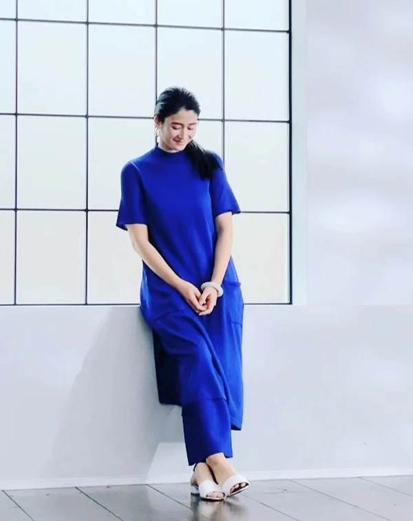 許多熟齡女性,容易對高飽和度色彩卻步,但其實像克萊因藍、寶藍...等這類冷調鮮豔色,提亮皮膚與襯托氣色的效果絕佳。「長版長袖上衣+寬褲」的同色系延伸穿法,能瞬間在視覺上拉長比例,同時完美遮擋腰腹與大腿線條。只需注意面料選擇帶有自然垂墜感的材質,並搭配一雙簡約的鞋款,就能輕鬆穿出俐落、大方的時尚態度。