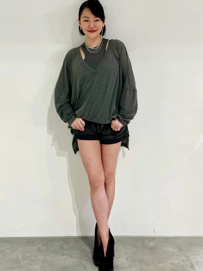 成熟女人的性感，是層次疊加出來的若隱若現。V領與內搭背心的雙層領口設計，巧妙修飾了小S頸部與鎖骨線條，再搭搭配上銀質項鍊的點綴，將看似休閒的灰黑色系，穿出了高級的輕奢感。40+歲若想嘗試微露肌膚，「多層次領口」是最安全的選擇，不必大面積裸露，透過不同領口線條的堆疊，既能修飾臉型與頸部，又能展現優雅的小心機。