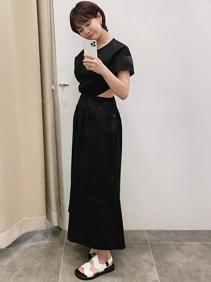 黑色連身裙，是熟齡女性的衣櫥必備，但全黑容易顯得沉重。選擇帶有「微鏤空」、「開衩」或「特殊剪裁」的款式，就可以在視覺上創造空間感與輕盈度；再搭配一雙有設計感的平底涼拖，既不失莊重，又能流露不經意的性感。
