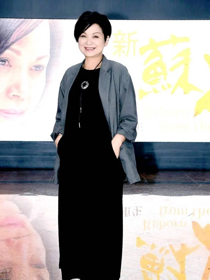 楊貴媚選擇了黑色連身洋裝作為基底,外罩一件沉穩的灰色解構風開襟罩衫,脖子上繫著一條精緻的長項鍊。整體造型以低彩度的黑、灰色為主,流露出濃厚的人文藝術氣息,不需要過多的花俏裝飾,光靠剪裁與層次就足夠高級。喜歡低調、沉穩風格的同齡人,可以善用「同色系深淺搭配」(如黑加灰),利用長版罩衫製造縱向延伸感,不僅能修飾身形線條,還能營造出溫柔、知性且富有層次的文藝質感。
