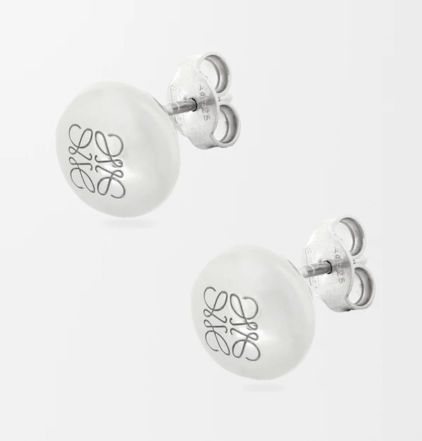 Loewe總能把幾何美學與藝術感平衡得剛剛好！這款「Anagram Pebble」耳環，巧妙地將溫潤圓滑的鵝卵石輪廓結合品牌經典的Anagram四L標誌，純銀質地經過極致拋光，散發出低調卻高級的金屬光澤。小巧精緻的貼耳設計，非常適合追求極簡、帶有一點文青氣質的質感男女，是能悄悄為穿搭加分的夢幻小巧思。（商品價格約：NTD 15,044）