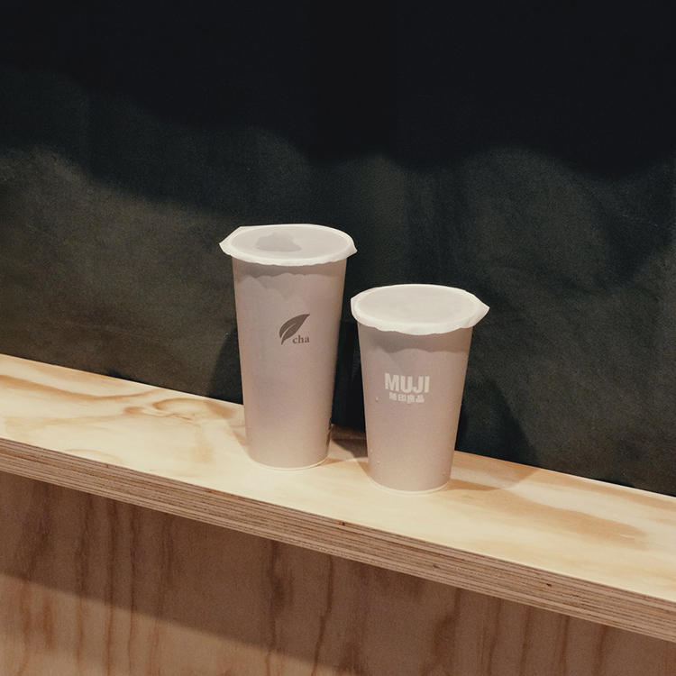 無印良品在微風松高開手間飲料店，綠色櫥窗前擺著兩杯灰色瓶身的手搖杯。