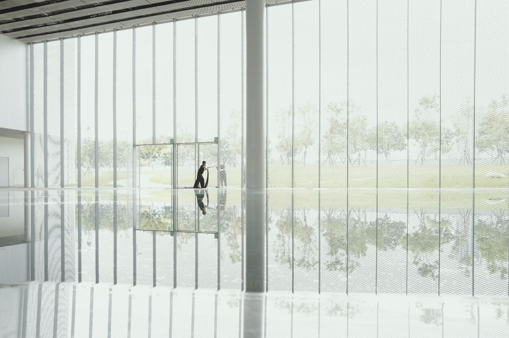 台中綠美圖透過 8 個主量體，將兩單位的空間機能相互串連，大廳挑高達 27 米，引入自然光線之餘，也能策劃大型裝置藝術。