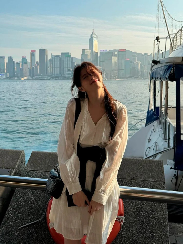 韓韶禧現身香港旅遊，白色連身裙搭配Philomena鍊條半月斜背包為造型亮點。