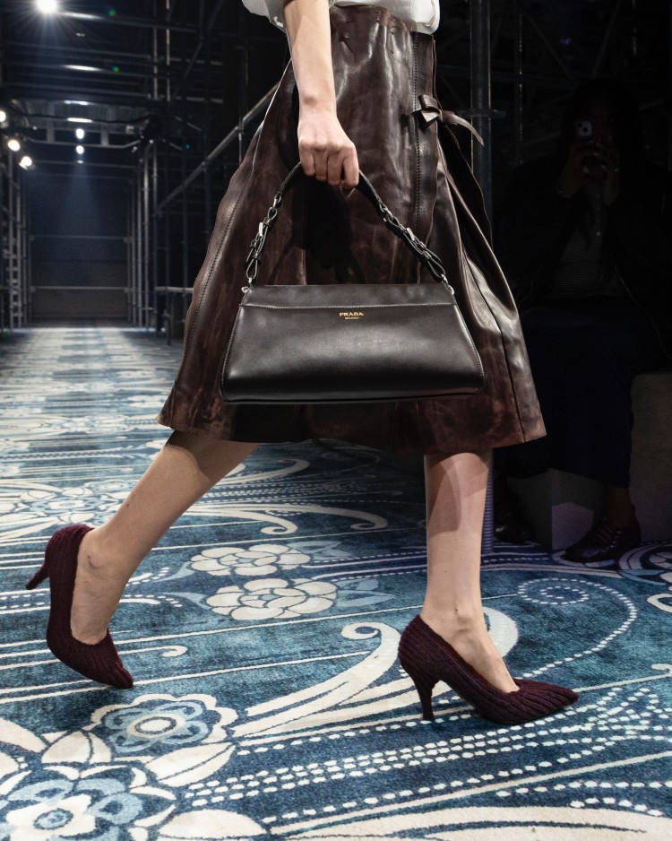 以俐落剪裁塑造包身如雕刻般,兩側以綁結造型定調輪廓,開口則以磁扣方式收合,細節藏著不費力的風格態度。