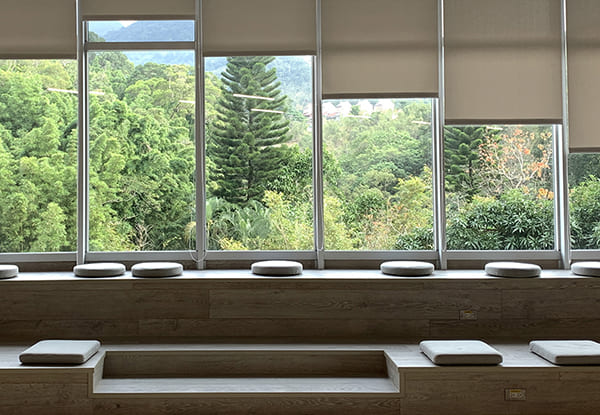 三面採光的面湖景緻，色澤溫柔的木製桌椅，為閱讀帶來不同的感受。除了室內的閱讀空間，能眺望到湖畔美景，這裡，也鼓勵讀者帶著一本書，走到室外，漫步於池畔的青青草坪，透過空間的串連，打造豐富的閱讀體驗，不單單停於室內。