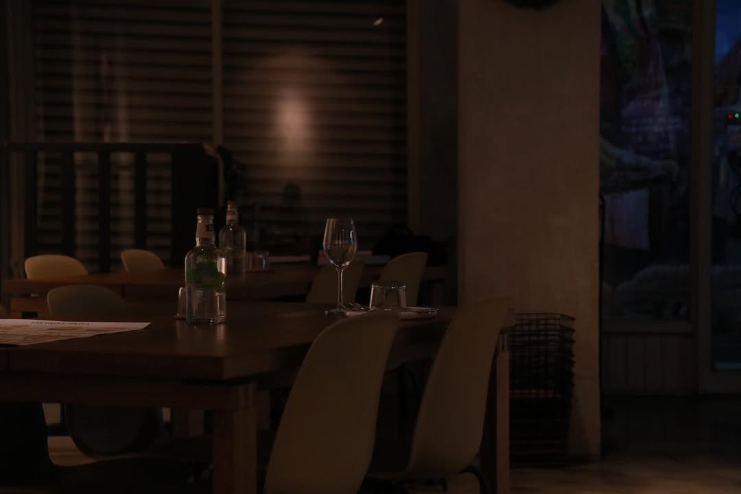 以灰白水泥、溫潤木質與柔黃燈光勾勒出極簡卻有溫度的餐廳。