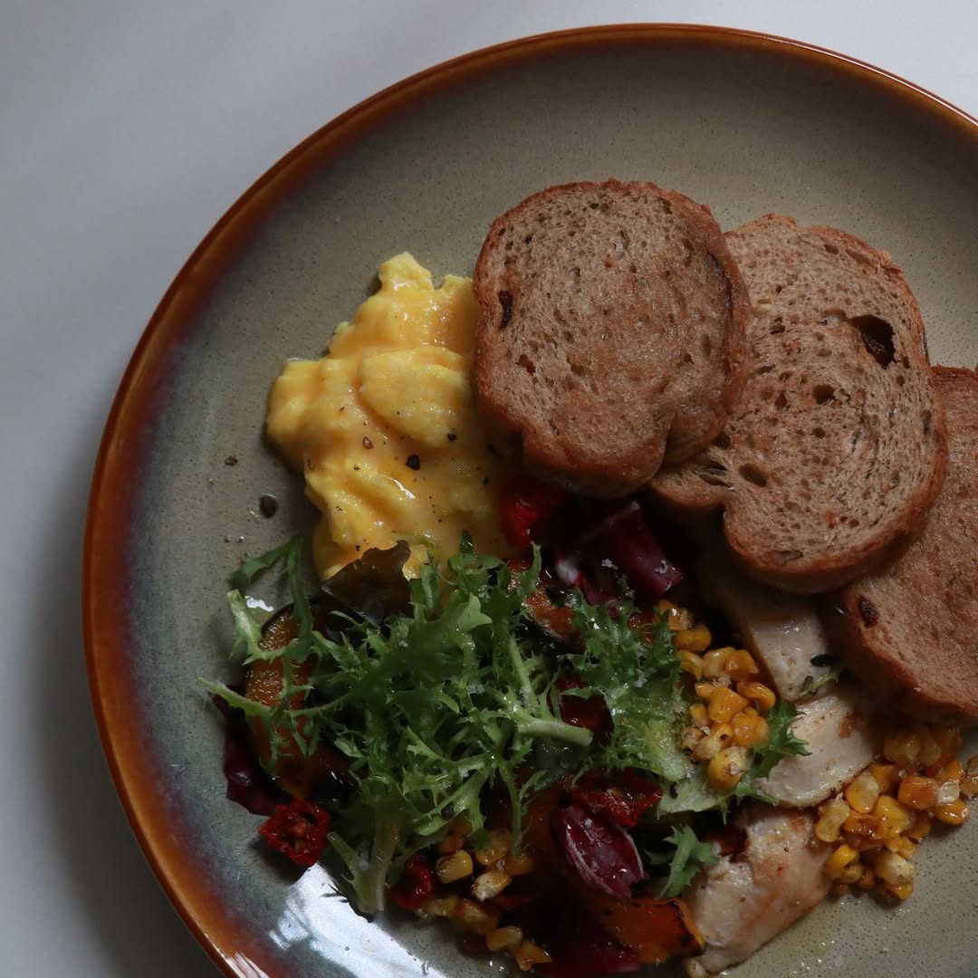 人氣可頌拼盤以高級奶油可頌配自製瑞可塔、酪梨與滑蛋,清爽而平衡。